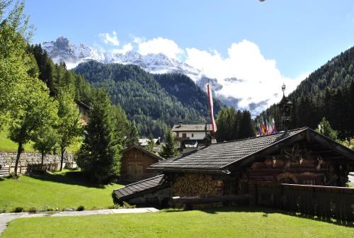 a log cabin with a mountain in the background at Romantik Villa Cesanueva in Selva di Val Gardena