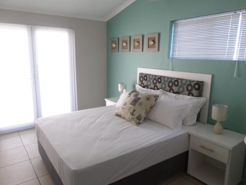 a bedroom with a bed with white sheets and pillows at Beach House Bliss in Langebaan