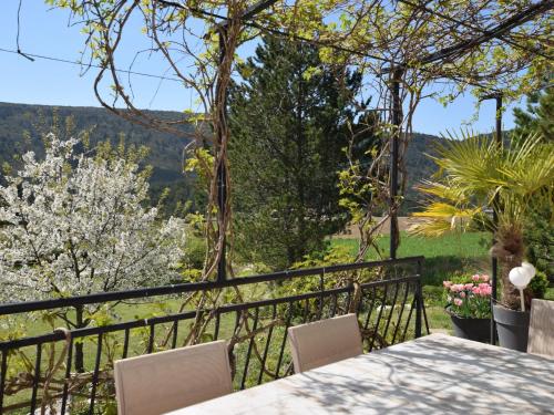 uma vista a partir da varanda de uma casa com uma mesa e cadeiras em Quiet holiday home with garden em Ponet-et-Saint-Auban
