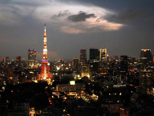 a city skyline with the eiffel tower lit up at night at APA Hotel Shinjuku Kabukicho Tower in Tokyo