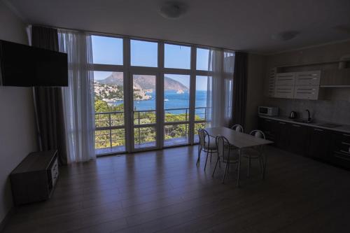 a kitchen with a table and chairs and a large window at Veseliy Hotey in Gurzuf