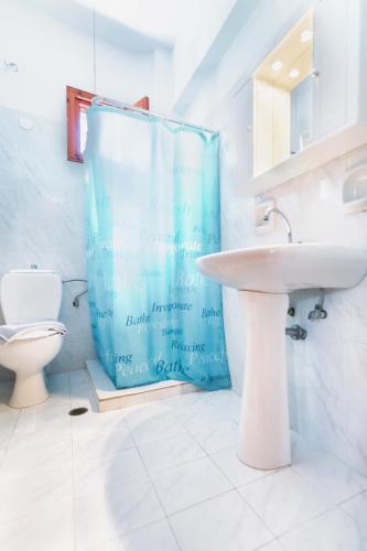 a bathroom with a sink and a toilet at Saint Nicolas Bungalows in Arkasa