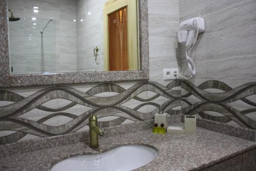 een badkamer met een wastafel en een spiegel bij Paradise Hotel in Tbilisi City