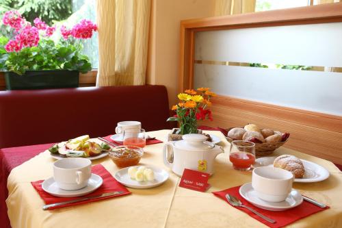 ein Tisch mit Tassen und Teller mit Essen drauf in der Unterkunft Alphotel Milano in Andalo