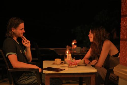 Un hombre y una mujer sentados en una mesa en Deshadan Cliff & Beach Resort,Varkala, en Varkala