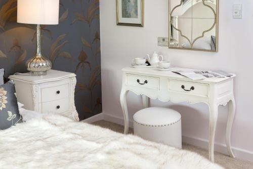 a white dressing table with a stool and a lamp at The Traveller's Rest in Grasmere