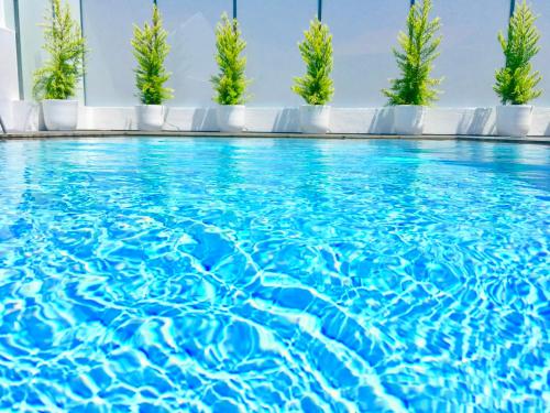 a swimming pool with blue water and green trees at Luxury Villa with Private Pool e Jacuzzi Year-Round a 25 min de Lisboa in Setúbal