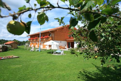 a building with a yard with white tables and chairs at Pension Schweizerhaus Garni in Weyarn
