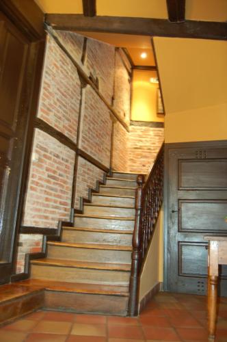 a stairway leading up to a room with a brick wall at Hotel La Posada Regia in León