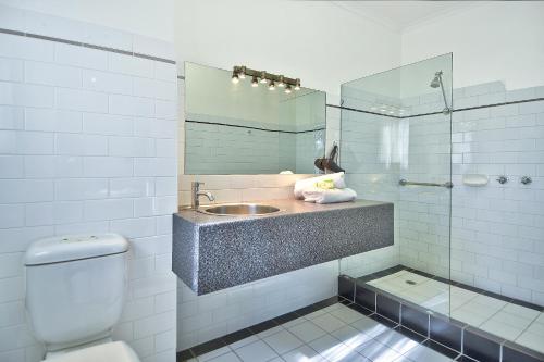 a bathroom with a sink and a toilet and a mirror at BEST WESTERN Geelong Motor Inn & Serviced Apartments in Geelong