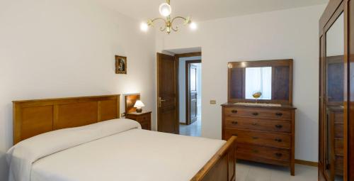 a bedroom with a bed and a dresser and a mirror at La Casa dei Pini in Gubbio