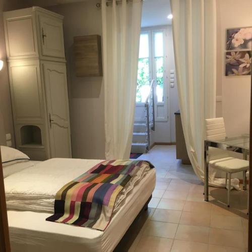 une chambre avec un lit, un bureau et une fenêtre dans l'établissement Sainte Maxime Studio 2, à Sainte-Maxime