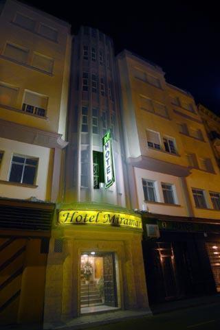 a tall building with a sign in front of it at Hotel Miramar in La Línea de la Concepción