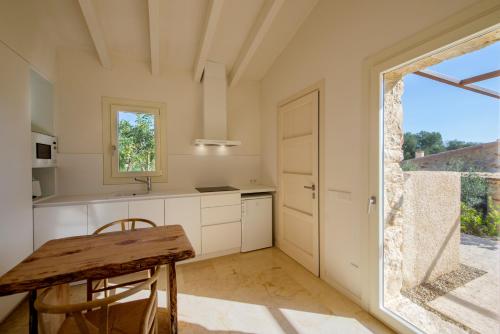 a kitchen with a wooden table and a large window at Es Lligats Agroturismo - Adults Only in Sant Llorenç des Cardassar