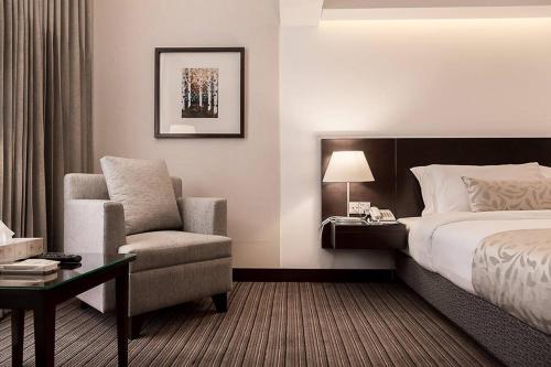 a hotel room with a bed and a chair at Hotel Windy Terrace in Cox's Bazar