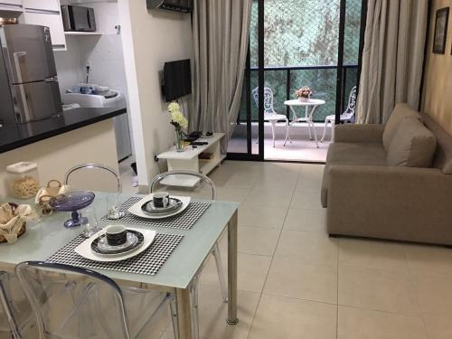 Il comprend une cuisine et un salon avec une table et des chaises. dans l'établissement Conforto E Localizacao, à Salvador