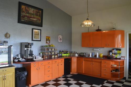 a kitchen with orange cabinets and a checkered floor at Retro Inn at Mesa Verde in Cortez