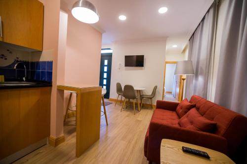 a living room with a red couch and a kitchen at Apartments Madeira City Center in Funchal