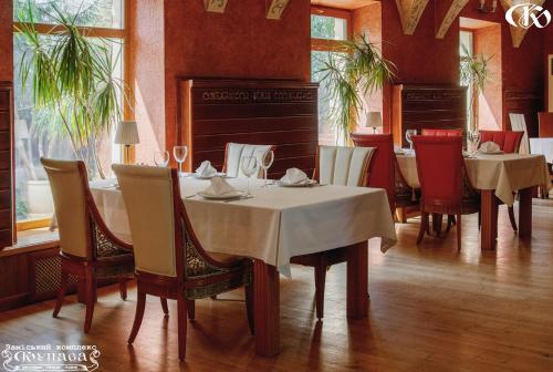 a dining room with tables and chairs in a restaurant at Hotel Complex Kupava in Podvorki