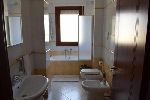 a bathroom with a sink and a toilet and a window at suite the natural color in Selargius