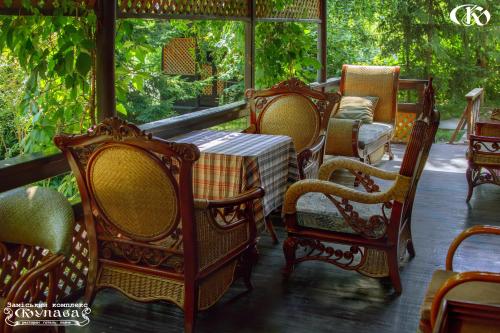 a porch with a table and chairs on a porch at Hotel Complex Kupava in Podvorki