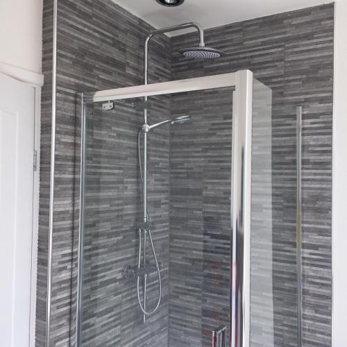 a shower with a glass door in a bathroom at Baker's Dozen in Stratford-upon-Avon