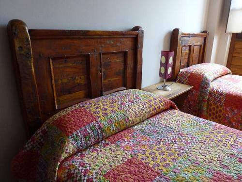 フォルミガルにあるApartamentos Formigal - admite mascotasのベッドルーム1室(ベッド2台、木製ヘッドボード付)