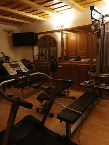 a room with a gym with a treadmill and a desk at Vitis Vendégház in Becsehely