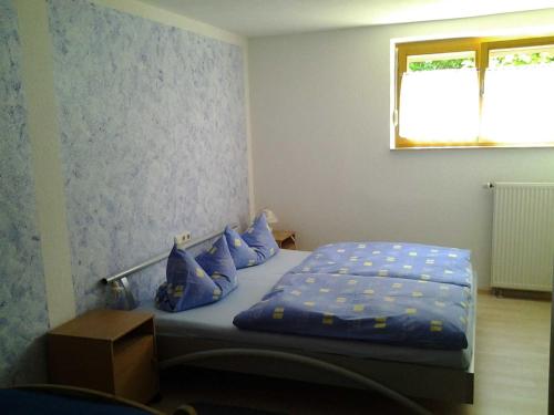 マールベルクにあるFerienwohnung Dettweilerのベッドルーム1室(青い枕のベッド1台、窓付)