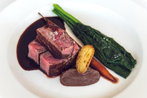 a plate of steak and vegetables on a white plate at Hotel Riviera dei Fiori in San Lorenzo al Mare