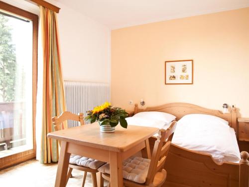 Un dormitorio con una cama y una mesa con flores. en Gasthof Waldschenke, en Bad Leonfelden