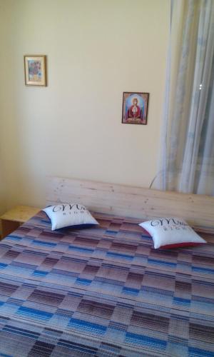 a bedroom with a bed with two pillows on it at Casa Cosmin in Dobra