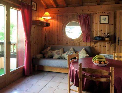 Cette chambre comprend un canapé et une table avec un bol de fruits. dans l'établissement Les Jardins Alpins - Apartment, à Saint-Gervais-les-Bains