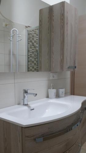 a bathroom with a white sink and a mirror at La casa di Laura in Tortolì