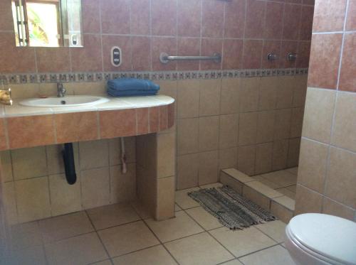 a bathroom with a toilet, sink, and tub at Hotel Cabinas Tropical in Puerto Viejo