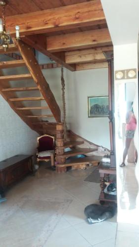a person standing under a wooden stairs in a room at SielskoAnielsko k. Karpacza in Łomnica