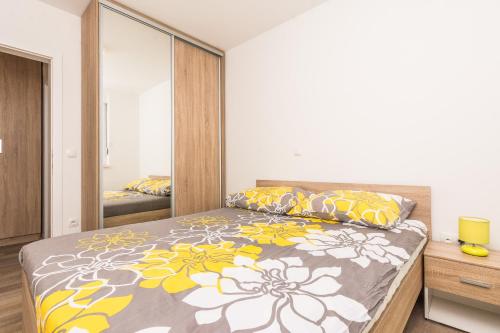 普萊克的住宿－Apartments Sunrise，一间卧室配有一张带黄色和白色枕头的大床