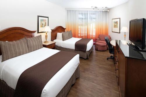 a hotel room with two beds and a flat screen tv at Red Lion Hotel Boise Downtowner in Boise