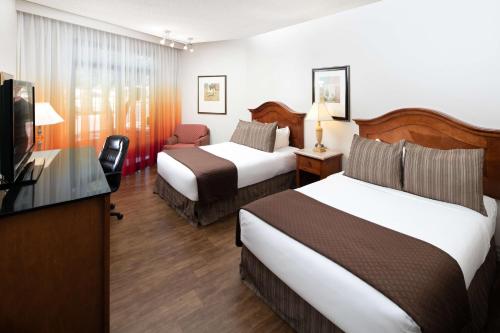 a hotel room with two beds and a flat screen tv at Red Lion Hotel Boise Downtowner in Boise