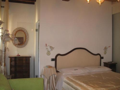 1 dormitorio con cama y espejo en la pared en B&B Casa Delle Rose, en Antria