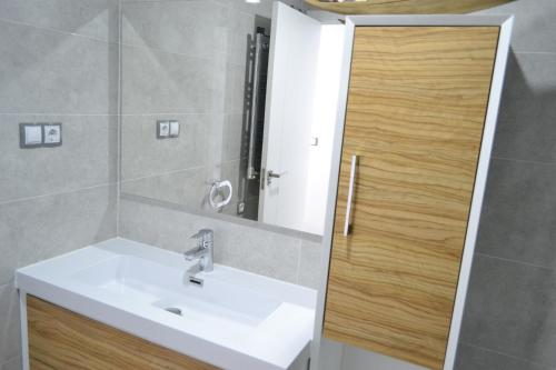 une salle de bain avec un lavabo et un miroir dans l'établissement Amazing Infinity View Apartment, à Arenales del Sol