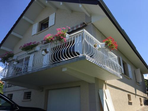 un edificio con un balcón con flores. en villa maxilly, en Maxilly-sur-Léman