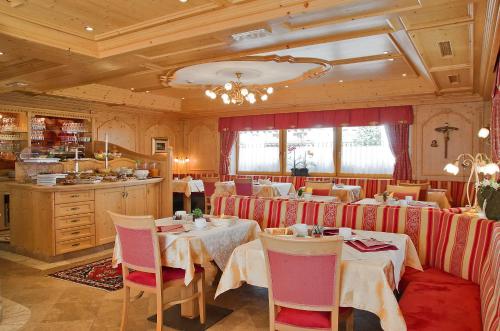un ristorante con tavoli e sedie in una stanza di Mountain B&B - La Scalira a Corvara in Badia