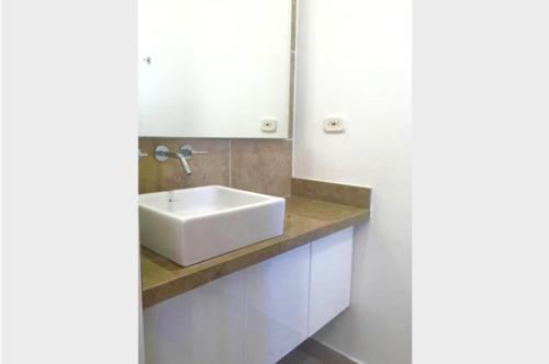 y baño con lavabo blanco y espejo. en Condominio Zazue Bello Horizonte, en Santa Marta