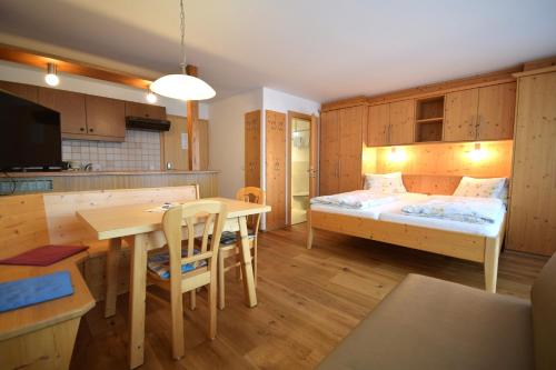 a room with a bed and a table and a kitchen at Gästehaus Waltl in Krimml