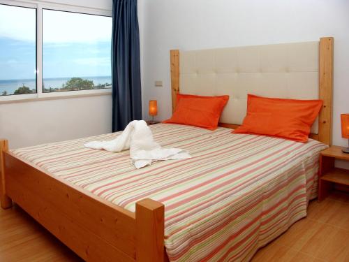 um quarto com uma cama grande e almofadas laranja em Apartamentos Maritur em Albufeira