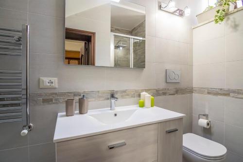 a bathroom with a sink and a toilet and a mirror at Villa Lazzari B&B Tra i due Mari in Maglie