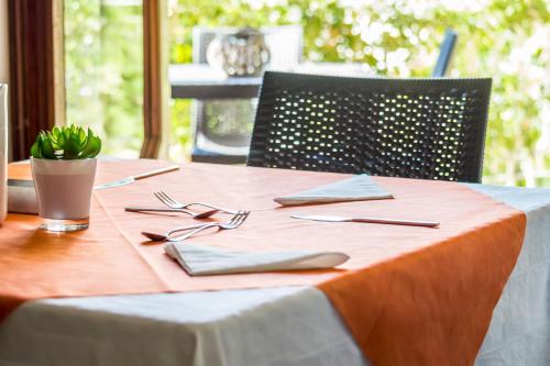 a table with a orange table cloth and utensils on it at Villa Lazzari B&B Tra i due Mari in Maglie