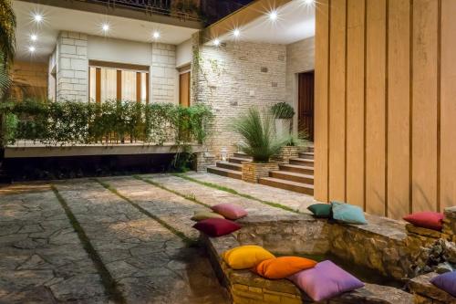 a group of pillows sitting on a bench in a courtyard at Villa Lazzari B&B Tra i due Mari in Maglie