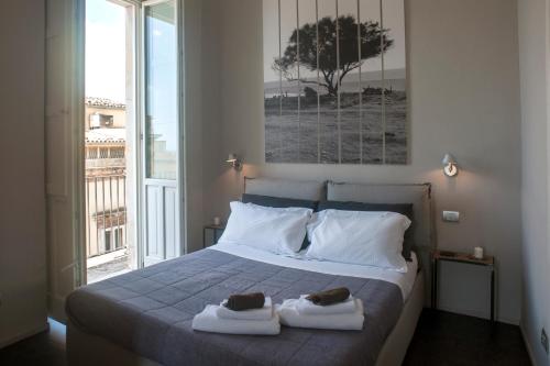 a bedroom with a bed with two towels on it at Kalote' Apartments in Noto